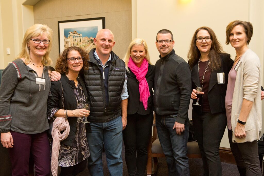 Group of people grouped together and smiling at the camera.