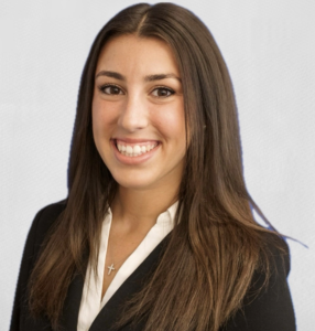 Young woman with long brown hair smiling.