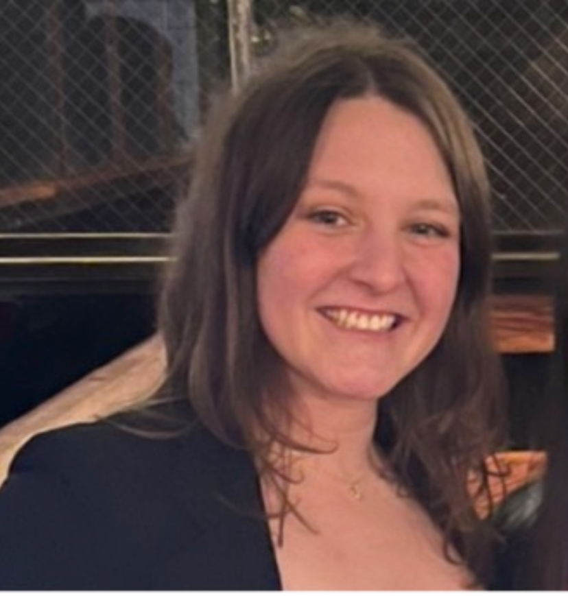 Young woman with long brown hair, smiling.