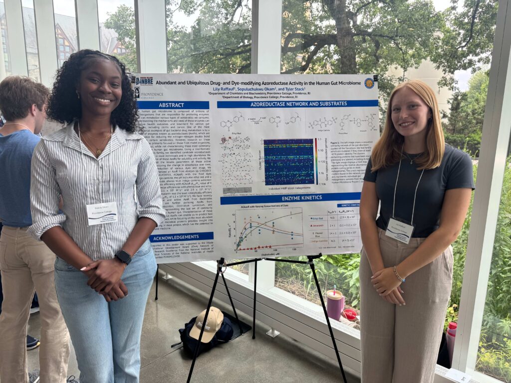 Students standing by a poster presentation.