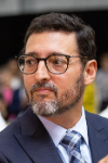 Man with dark hair, glasses and a beard.
