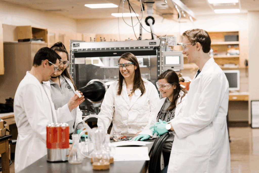 Dr. Maria Carroll in the lab with four students.