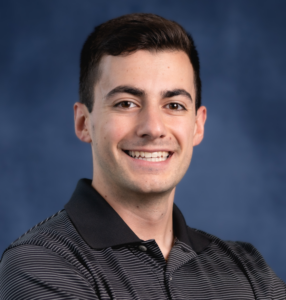 Man with dark brown hair with a big smile.